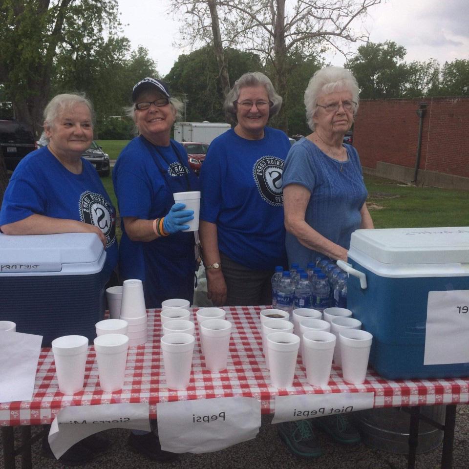 Various ladies serving soda in Styrofoam cups